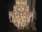 The image shows a chandelier made using empty covid vaccin vials.