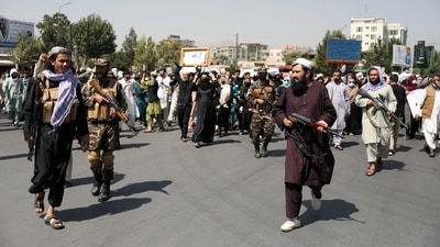 Taliban soldiers walk in front of an anti-Pakistan protest in Kabul, Afghanistan. (West Asia News Agency via Reuters)