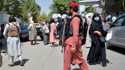 Taliban fighters keep vigil as Afghan women take part in an anti-Pakistan demonstration in Kabul. (AFP)