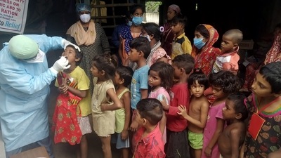 A healthcare worker collects swab samples of the underprivileged children for Covid-19 RT-PCR test in Kolkata. (ANI Photo)