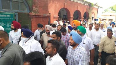 Shiromani Akali Dal chief Sukhbir Singh Badal being escorted to the court of the additional chief judicial magistrate in Hoshiarpur on Wednesday. (HT Photo)