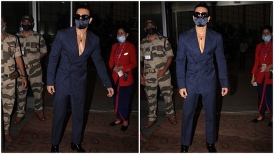 Ranveer arrived at the Mumbai airport in a pinstriped suit. He wore a navy-blue, double-breasted blazer featuring notch lapels without a shirt. And what's more, he absolutely rocked the look. (HT Photo/Varinder Chawla)