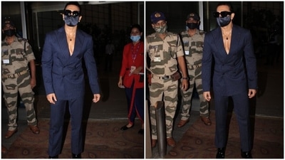 Ranveer teamed the tailored blazer with matching straight-fit pinstriped pants and a black face mask. He accessorised his outfit with black dress shoes, black-tinted sunglasses, and a silver chain with a pendant. (HT Photo/Varinder Chawla)