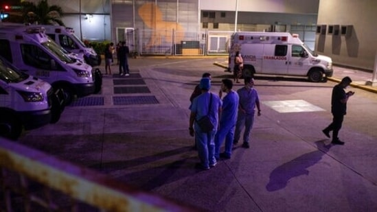 Health workers check on their mobile phones as they stand outside Veracruz General Hospital after a strong earthquake, in Veracruz, Mexico, Tuesday, Sept. 7, 2021. The quake struck southern Mexico near the resort of Acapulco, causing buildings to rock and sway in Mexico City nearly 200 miles away. (AP Photo/Felix Marquez)