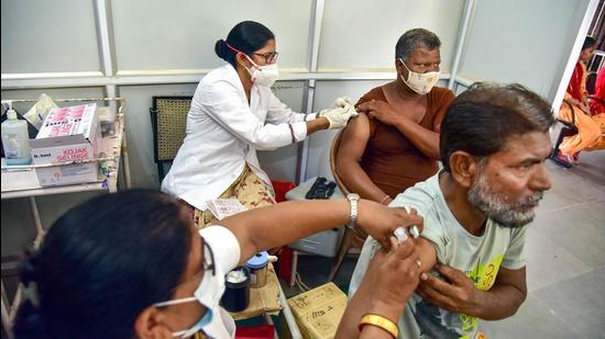 Health workers inoculate Covid-19 vaccine doses to beneficiaries at a special vaccination camp targeting 100,000 doses in a single day, in Bikaner on Wednesday. (PTI)