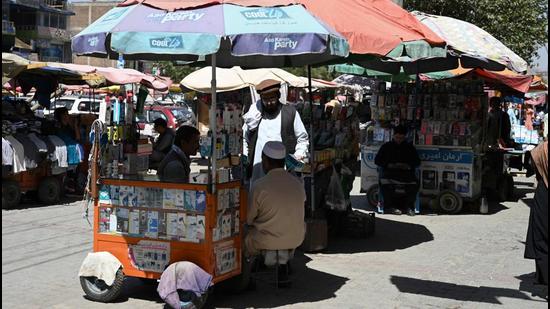Men shop at a stall selling mobile accessories at a market in Kot-e Sangi area in Kabul on Wednesday. China will donate grains, winter supplies, vaccines, and medicines to Afghanistan. (AFP)
