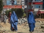 A banner with a picture of late Afghan commander Ahmad Shah Massoud is installed next to residential buildings as burqa-clad Afghan women walk along an under-construction road in Kabul. A banner with a picture of late Afghan commander Ahmad Shah Massoud is installed next to residential buildings as burqa-clad Afghan women walk along an under-construction road in Kabul.