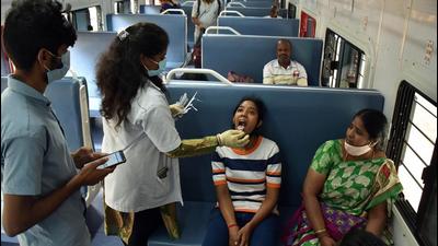 A healthcare worker collects a swab sample of a girl for the Covid-19 test inside a train compartment in Bengaluru. (ANI) A healthcare worker collects a swab sample of a girl for the Covid-19 test inside a train compartment in Bengaluru. (ANI)