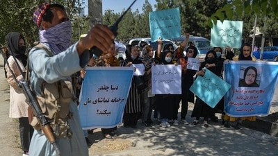 A Taliban fighter stands guard as Afghan women take part in an anti-Pakistan protest in Kabul, on Wednesday. (AFP Photo) A Taliban fighter stands guard as Afghan women take part in an anti-Pakistan protest in Kabul, on Wednesday. (AFP Photo)