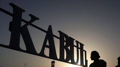 Taliban soldiers stand in front of a sign at the international airport in Kabul, Afghanistan, September 9, 2021. (via Reuters)