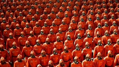 In this photo provided by the North Korean government, North Korean troops wearing gas masks and bright red suits parade during a celebration of the nation’s 73rd anniversary that was overseen by leader Kim Jong Un, at Kim Il Sung Square in Pyongyang, North Korea, early Thursday, Sept. 9, 2021. (Korean Central News Agency/Korea News Service via AP)