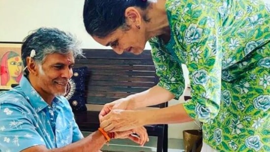 Another sister of Milind Soman ties rakhi on his hand. The smile on their faces says a lot about the bond they share.(Instagram/@milindrunning)