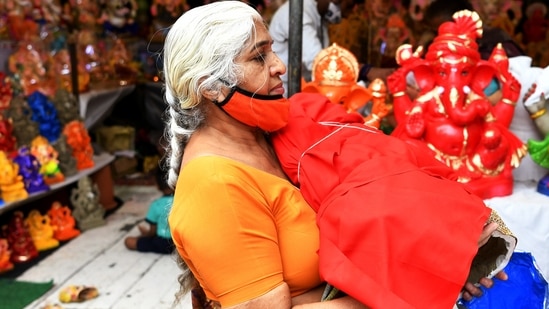 A devotee carries an Idol of Lord Ganesha to take home on the eve of the Ganesh Chaturthi festival, in New Delhi.(ANI)