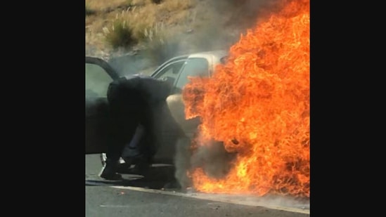 The image shows one of the bystanders rescuing a couple from a burning car.(Instagram/@lakesidefiredist)