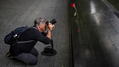 Shannon Stapleton takes photos of the 9-11 Memorial in New York City, on September 2, 2021. For Stapleton, the years that followed 9/11 were filled with professional success. In 2005, Reuters hired him as a staffer, and for the next 15 years, he travelled from one disaster or conflict to another. He rarely stopped to pause or reflect on that dark day, he says. He just kept going. (Carlos Barria / REUTERS)