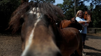 Kayla Bergeron is photographed by Shannon Stapleton with equine therapy horses in the fields at Special Equestrians of Georgia in Milton, Georgia, on July 3, 2021.&nbsp; (Shannon Stapleton / REUTERS)