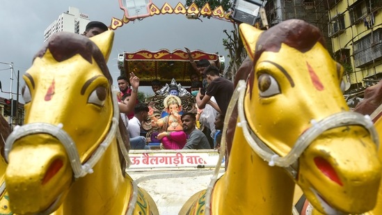 Devotees carries an idol of the Hindu god Lord Ganesha on the first day of the ten-day-long Ganesh Chaturthi festival at Lalbaug in Mumbai.&nbsp;(HT Photo/Anshuman Poyrekar)