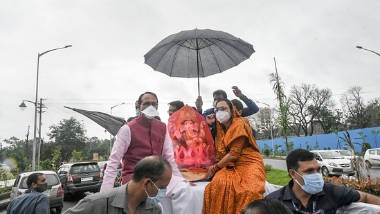 Madhya Pradesh Chief Minister Shivraj Singh Chouhan with wife Sadhna Singh, carries an idol of Lord Ganesha to install at his residence on the occasion of Ganesh Chaturthi, in Bhopal on September 10.(PTI)