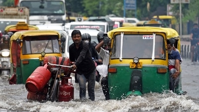 Commuters struggle to cross a waterlogged road after heavy rainfall near Vinod Nagar, in New Delhi. (ANI Photo) Commuters struggle to cross a waterlogged road after heavy rainfall near Vinod Nagar, in New Delhi. (ANI Photo)