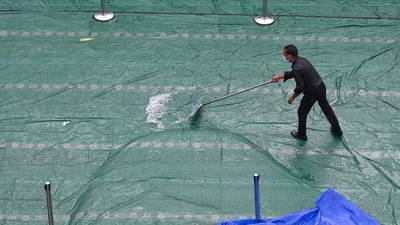 A man clears water from a rootop after a heavy downpour in New Delhi on September 11. (AFP)