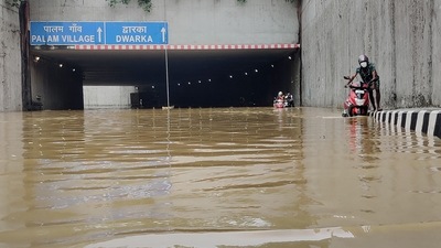 Commuters wade through a waterlogged underpass road at Palam after heavy rain in New Delhi on Saturday. (PTI) Commuters wade through a waterlogged underpass road at Palam after heavy rain in New Delhi on Saturday. (PTI)