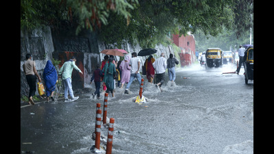 Pedestrians walking through a flooded street during rain in Jammu. (AP)