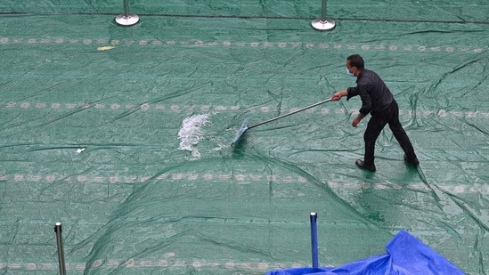 A man clears water from a rootop after a heavy downpour in New Delhi on September 11.(AFP)