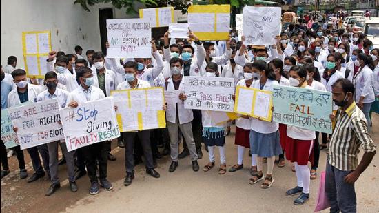 Students of MBBS 2019-20 batch holding placards and examination copies stage a protest in connection with their results at Patna Medical College and Hospital on Saturday. (ANI PHOTO.)