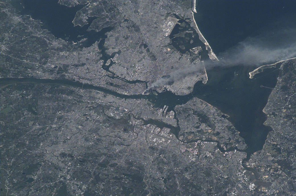 Uma nuvem de fumaça sobe da área de Manhattan depois que dois aviões se chocam contra as torres do World Trade Center. & Nbsp; (Nasa)