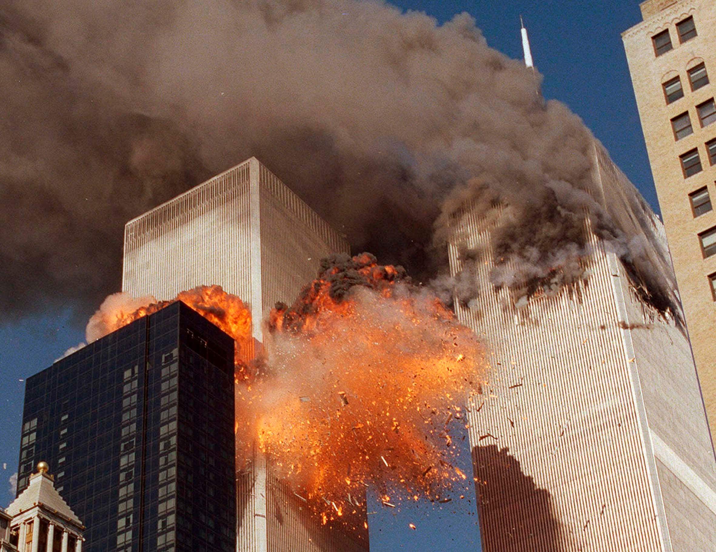 Smoke billows from one of the towers of the World Trade Center and flames and debris explode from the second tower. (AP)