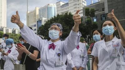 Medical workers give thumbs-up to their colleagues leaving to help during an outbreak of Covid-19 in Putian from a provincial hospital in Fuzhou in Fujian province in China on Sunday. (AP) Medical workers give thumbs-up to their colleagues leaving to help during an outbreak of Covid-19 in Putian from a provincial hospital in Fuzhou in Fujian province in China on Sunday. (AP)