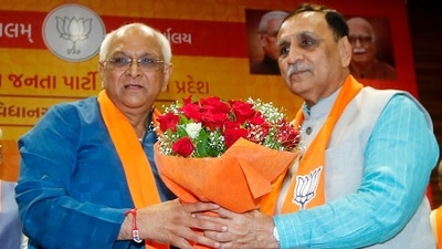 Former Gujarat chief minister Vijay Rupani greets the new CM Bhupendra Patel, at BJP headquarters in Gandhinagar. (ANI)