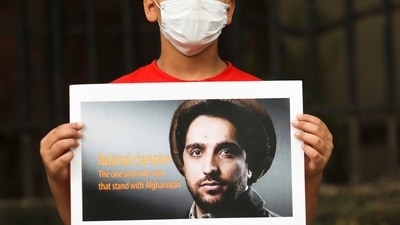 An Afghan boy holds up a sign with the image of Ahmad Massoud as he takes part in a protest against Pakistan in New Delhi.&nbsp; (Reuters Photo)