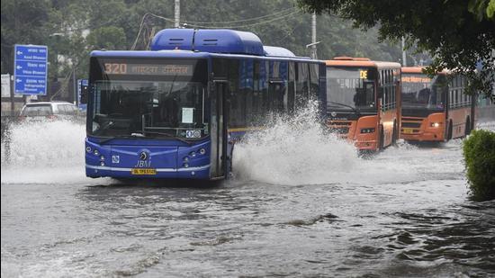 DTC buses pass through a waterlogged road at ITO after heavy rain in New Delhi on Saturday (Arvind Yadav/HT PHOTO)