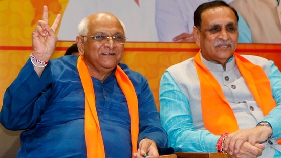 Newly elected Gujarat chief minister Bhupendra Patel shows victory sign in presence of his predecessor Vijay Rupani at the BJP headquarters in Gandhinagar on Sunday.(ANI)