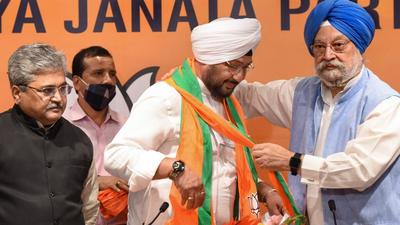 Inderjeet Singh (C), grandson of former President Giani Zail Singh, joins the BJP in the presence of Union Minister Hardeep Singh Puri in New Delhi on Monday. (PTI)
