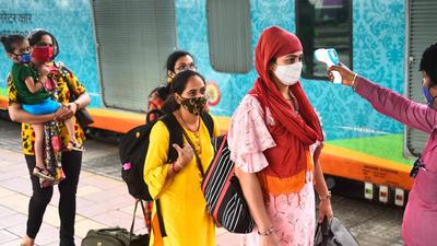 A BMC health worker checks temperatures before Covid-19 test of passengers arriving from outstation trains at Dadar station, in Mumbai on September 11. (HT file) A BMC health worker checks temperatures before Covid-19 test of passengers arriving from outstation trains at Dadar station, in Mumbai on September 11. (HT file)