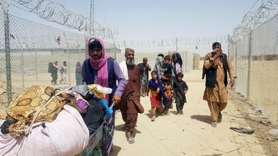 A family from Afghanistan walk next to fence to cross into Pakistan at the Friendship Gate crossing point, in the Pakistan-Afghanistan border town of Chaman. (REUTERS)