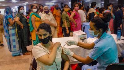 A health worker administers a dose of Covid-19 vaccine to a beneficiary, at a district hospital in Noida, on Monday. (PTI) A health worker administers a dose of Covid-19 vaccine to a beneficiary, at a district hospital in Noida, on Monday. (PTI)