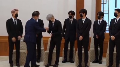 BTS members fist bump South Korean President Moon Jae-in.