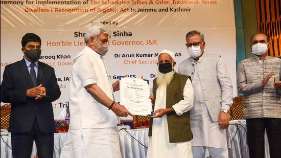 J&K L-G Manoj Sinha hands over the Forest Rights statutory document to a tribal beneficiary during a ceremony in Srinagar on Monday, Sept 13. (PTI)