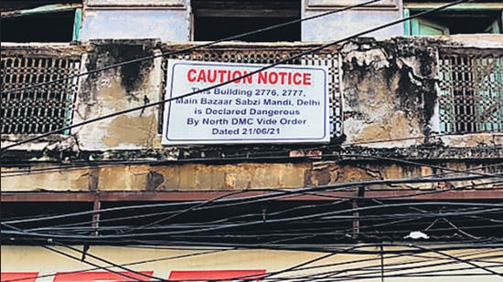 A notice put up by North Delhi Municipal Corporation on a building in Sabzi Mandi area, declaring it dangerous. A four-storey building in the area, near Robin Cinema, collapsed on Monday killing two children. (HT Photo)
