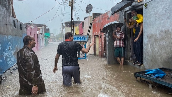 BJP workers ask locals to evacuate the area as heavy rains lash Gujarat's Rajkot and Jamnagar districts.(PTI)