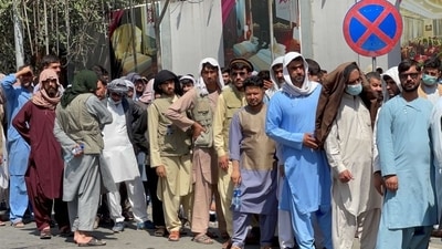 Afghans line up outside a bank to take out their money after Taliban takeover in Kabul. (Reuters Photo)