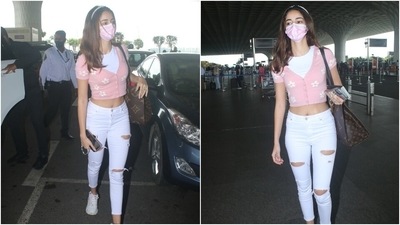 Ananya flaunted her toned midriff in the floral top and paired it with light blue distressed skinny denim pants. She completed the look with a pink face mask and white lace-up sneakers. (HT Photo/Varinder Chawla)