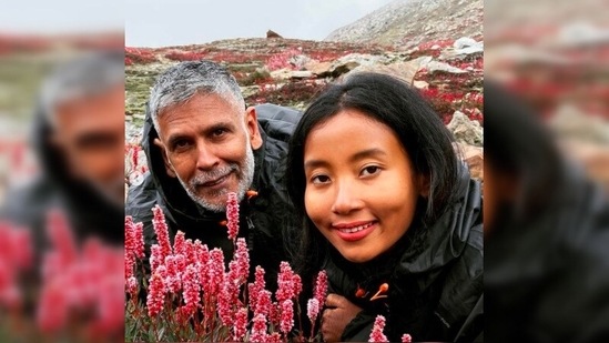 Milind Soman and his wife Ankita Konwar stopped to take a picture amidst the beautiful valleys of Gulmarg surrounded by bright pink flowers.(Instagram/@milindrunning)