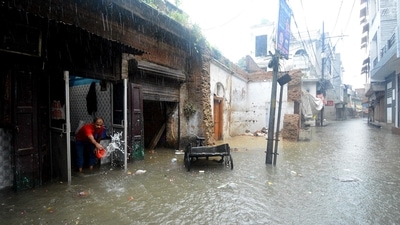 Shop owner removes water from his waterlogged shop as heavy rainfall wreaked havoc in UP's capital city Lucknow on Thursday. (ANI)