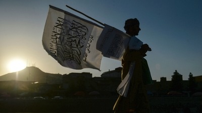 A man selling Taliban flags walks along a street in Kabul on September 15, 2021. (Photo by Hoshang Hashimi / AFP)