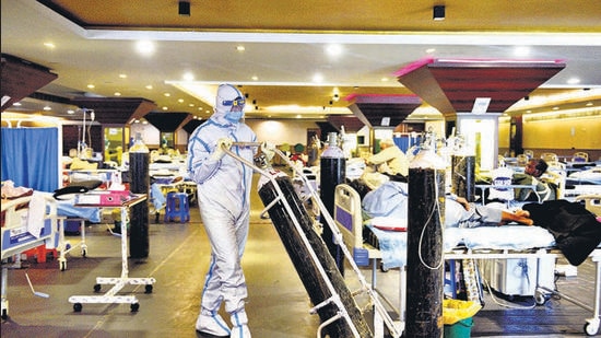 A health worker in PPE moving an oxygen cylinder at a Covid-19 care centre in New Delhi. Experts at the WRI Connect Karo conclave on Thursday said that the pandemic as presented people with an opportunity to plan the transformation in cities as the economy recovers. (Arvind Yadav/HT Photo) A health worker in PPE moving an oxygen cylinder at a Covid-19 care centre in New Delhi. Experts at the WRI Connect Karo conclave on Thursday said that the pandemic as presented people with an opportunity to plan the transformation in cities as the economy recovers. (Arvind Yadav/HT Photo)