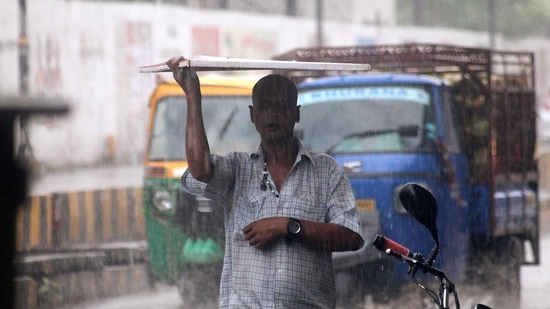 A man covers his head with a cardboard following incessant rainfall in Varanasi on Wednesday.(ANI Photo) A man covers his head with a cardboard following incessant rainfall in Varanasi on Wednesday.(ANI Photo)